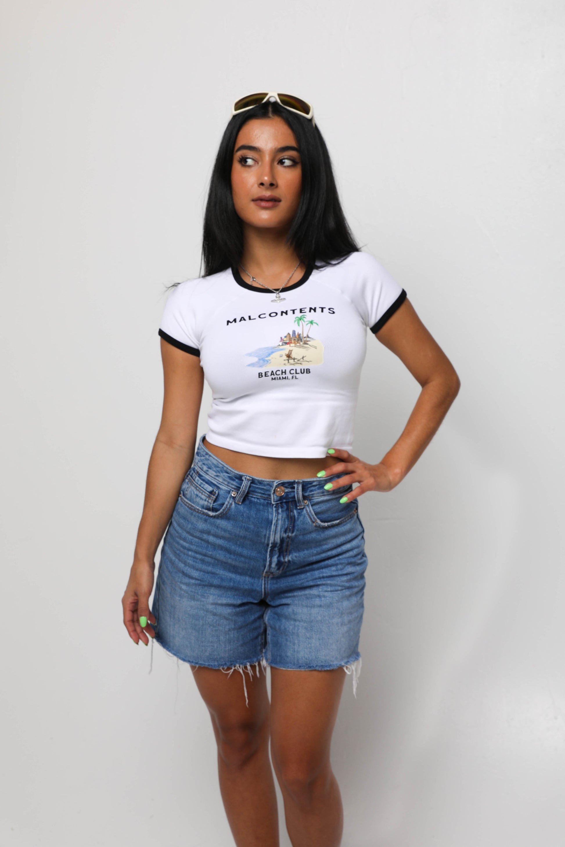 Female in white ringer crop top shirt with beach graphic.